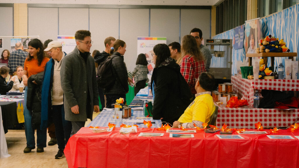 People strolling through the Maple Sugar Festival market, exploring local food, crafts, and community booths.