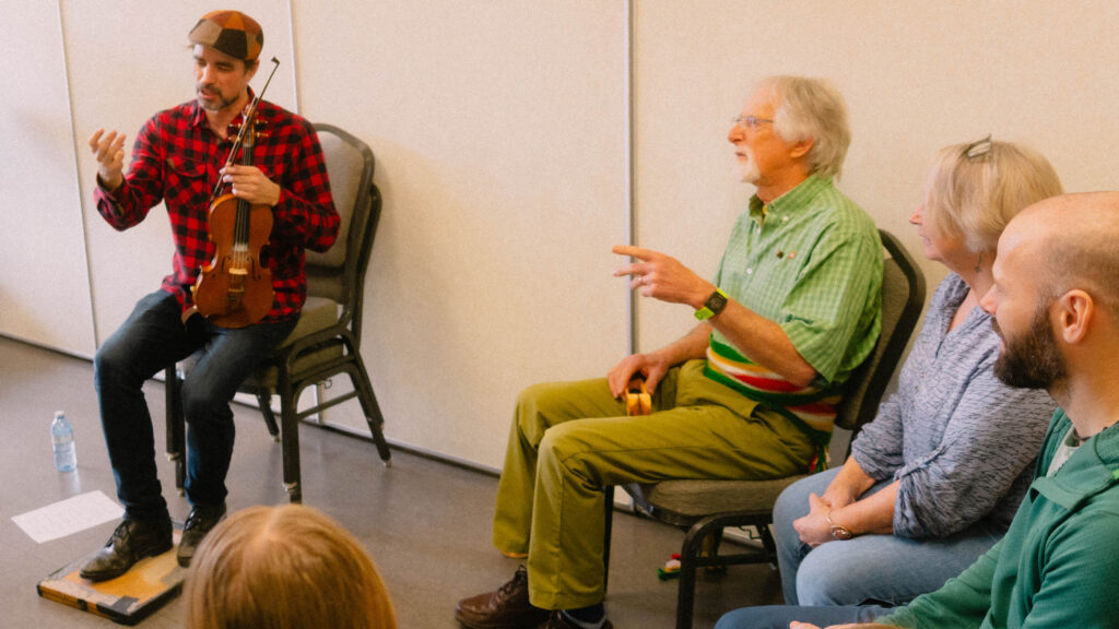Participants in a violin and Quebec rhythms workshop, focused and enjoying themselves during the Maple Sugar Festival workshops.