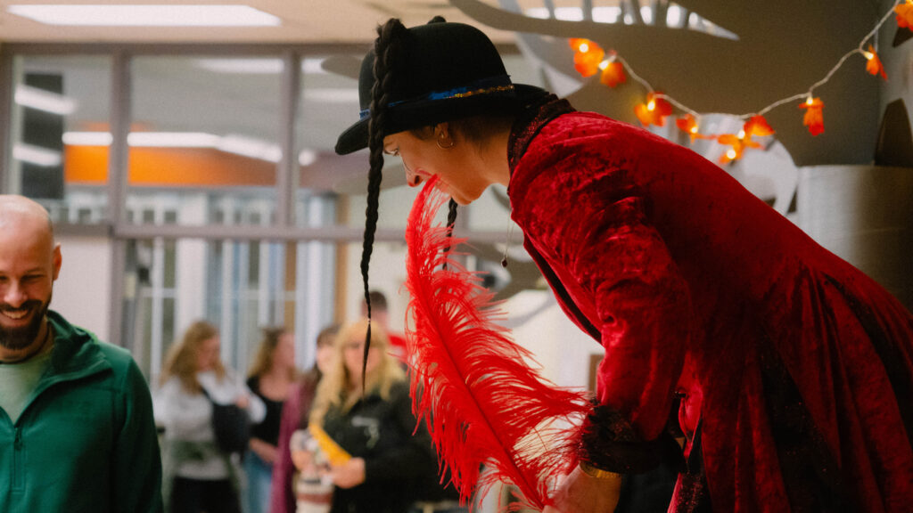 Lady clown on stilts strolling through the festival grounds and interacting with visitors.