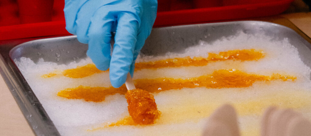 Photo of maple syrup being poured onto snow to make traditional taffy at the Maple Sugar Festival.