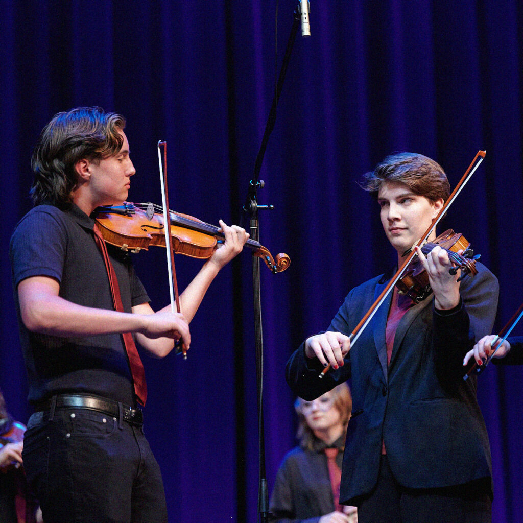 Photo of a group of young fiddlelists on stage.